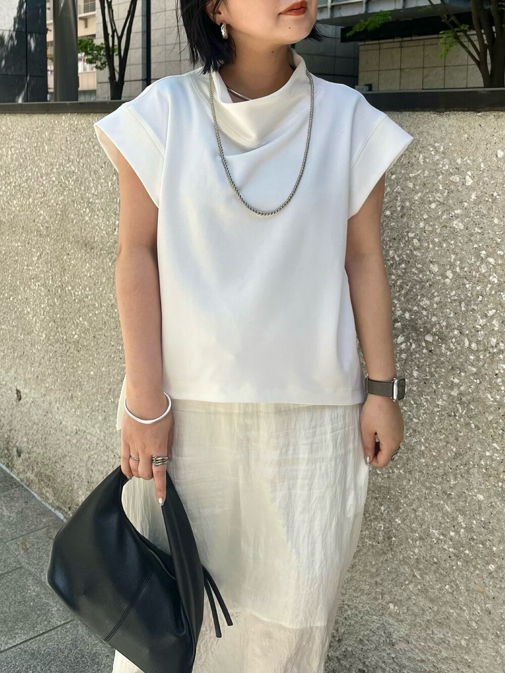 ホワイト系のTシャツ/カットソー、ホワイト系のスカート、ブラック系のサンダルを着用したレディースの春コーディネートの4枚目の写真