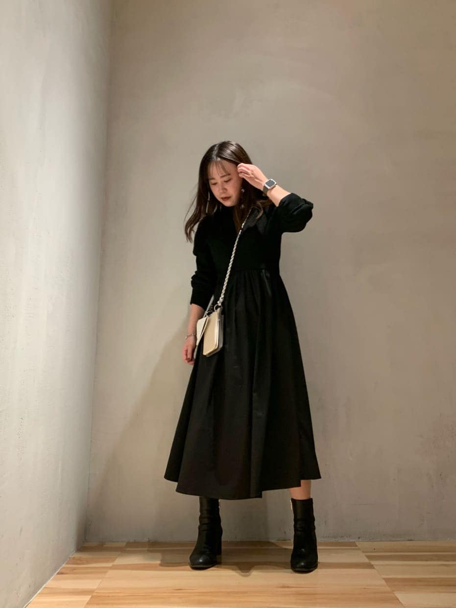 ベージュ系のショルダーバッグ、ブラック系のワンピースを着用したレディースの秋コーディネートの3枚目の写真