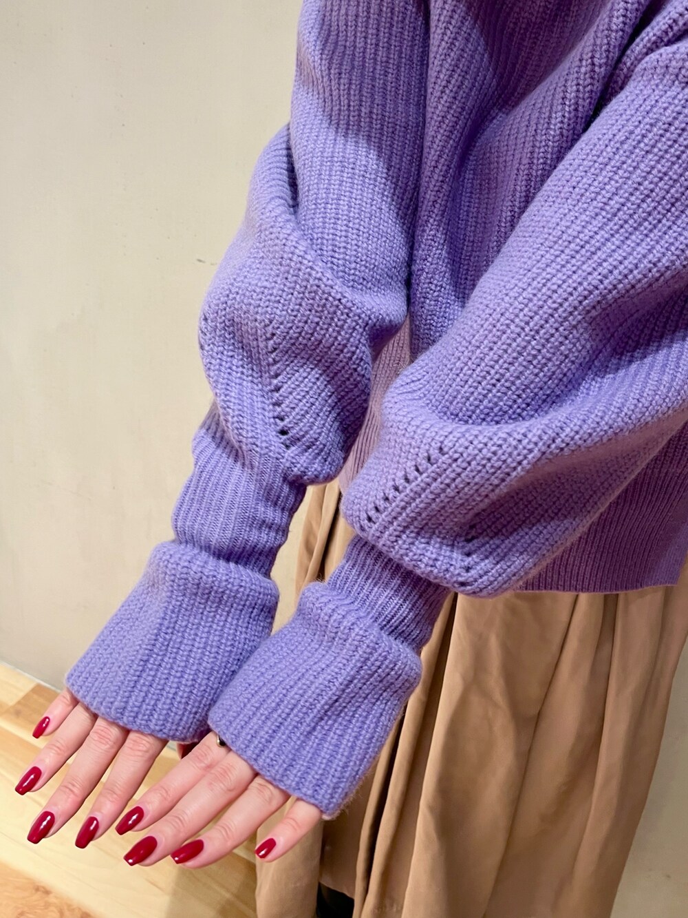 パープル系のニット/セーター、ベージュ系のスカート、パープル系のストール/ショールを着用したレディースの冬コーディネートの7枚目の写真