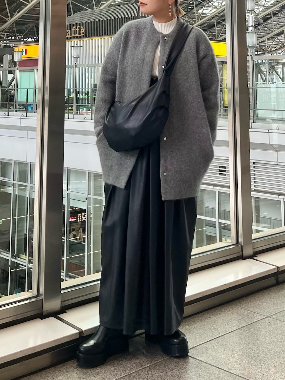 グレー系のノーカラージャケット、ブラック系のジャンパースカート、ホワイト系のニット/セーターを着用したレディースの秋コーディネートの4枚目の写真