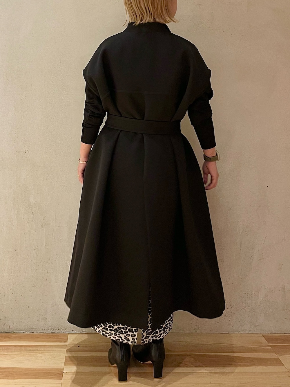 ブラック系のTシャツ/カットソー、ホワイト系のスカート、ブラック系のブーツを着用したレディースの春コーディネートの3枚目の写真