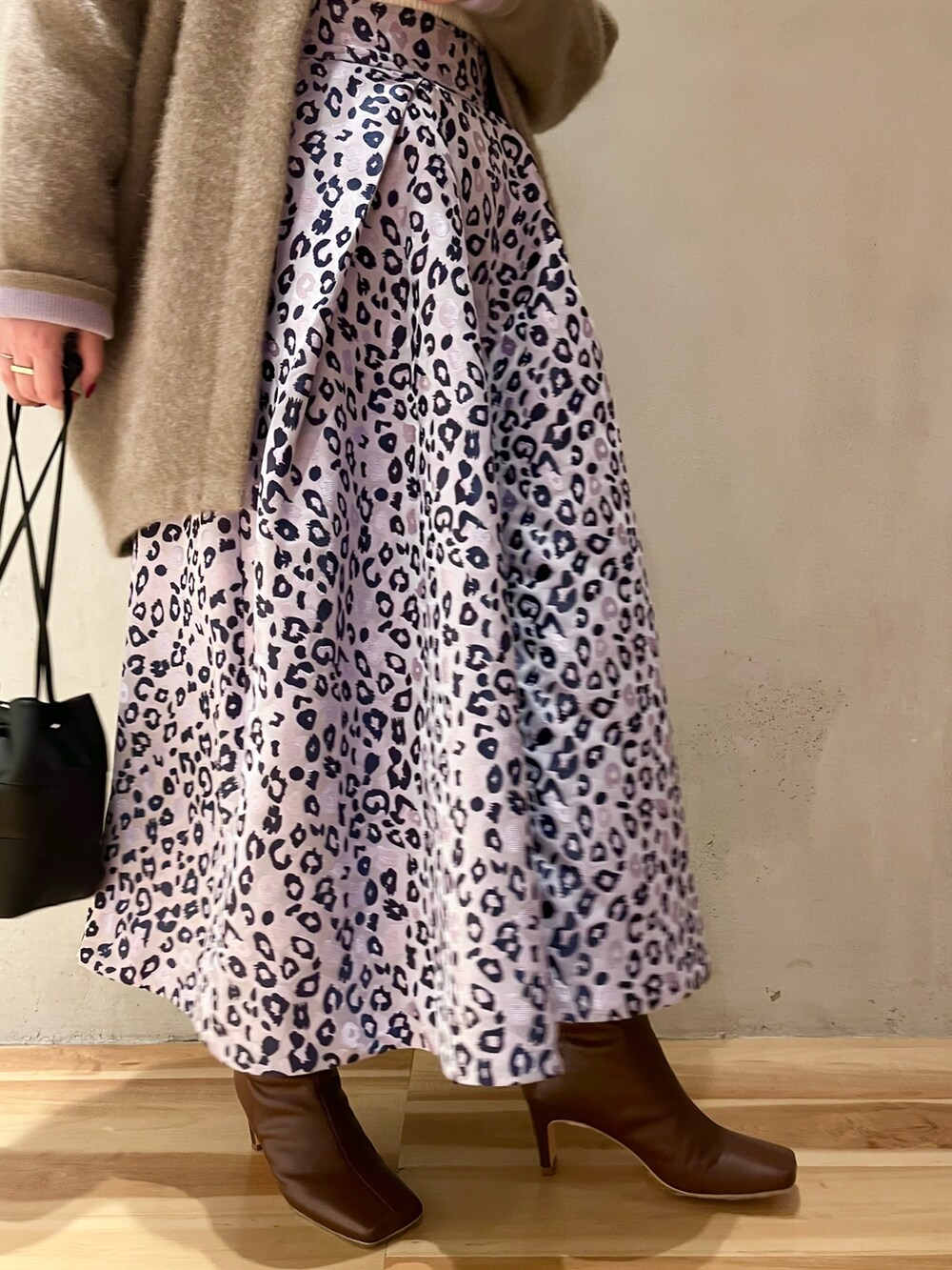 ホワイト系のニット/セーター、パープル系のスカート、ブラウン系のブーツを着用したレディースの冬コーディネートの7枚目の写真