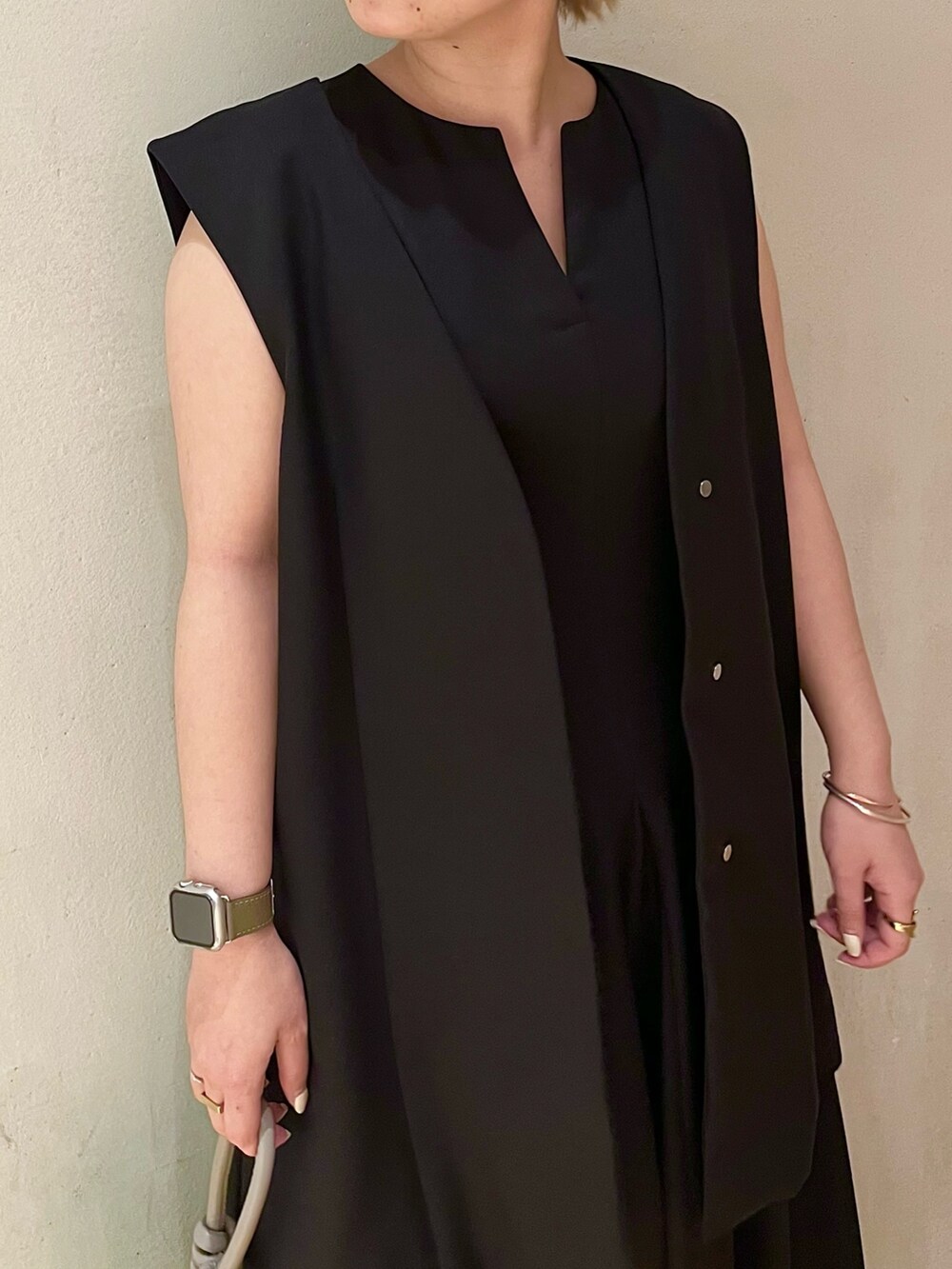 ブラック系のテーラードジャケット、ブラック系のワンピース、グリーン系のハンドバッグを着用したレディースの冬コーディネートの4枚目の写真