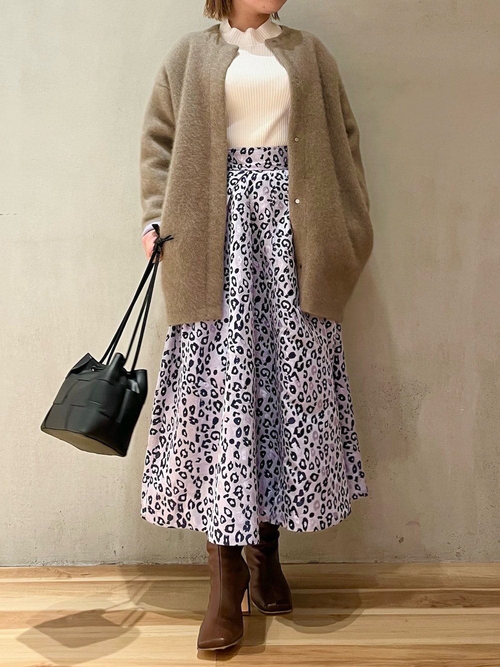 ホワイト系のニット/セーター、パープル系のスカート、ブラウン系のブーツを着用したレディースの冬コーディネートの4枚目の写真