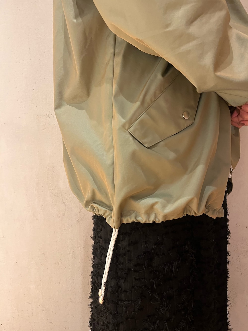 グリーン系のミリタリージャケット、ブラック系のワンピースを着用したレディースの春コーディネートの9枚目の写真