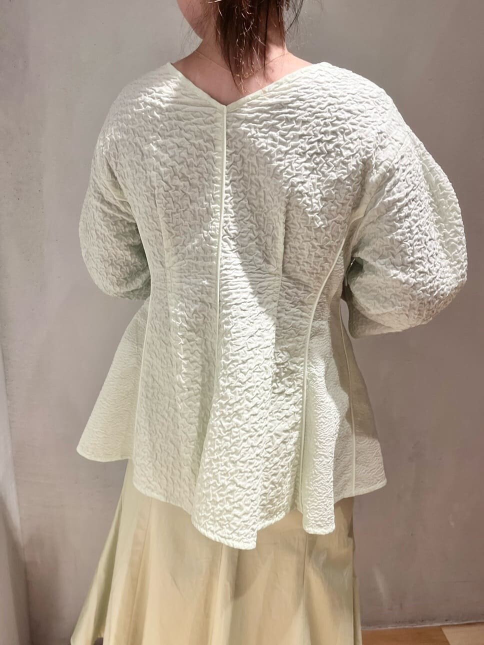 ベージュ系のステンカラーコート、グリーン系のスカート、グリーン系のシャツ/ブラウスを着用したレディースの春コーディネートの6枚目の写真