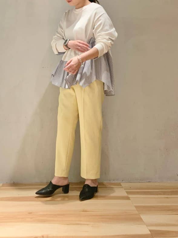 イエロー系のその他パンツ、ホワイト系のニット/セーターを着用したレディースの冬コーディネートの2枚目の写真