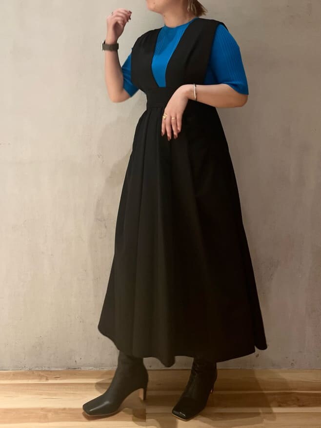 ブルー系のニット/セーター、ブラック系のジャンパースカート、ブラック系のブーツを着用したレディースの夏コーディネートの4枚目の写真