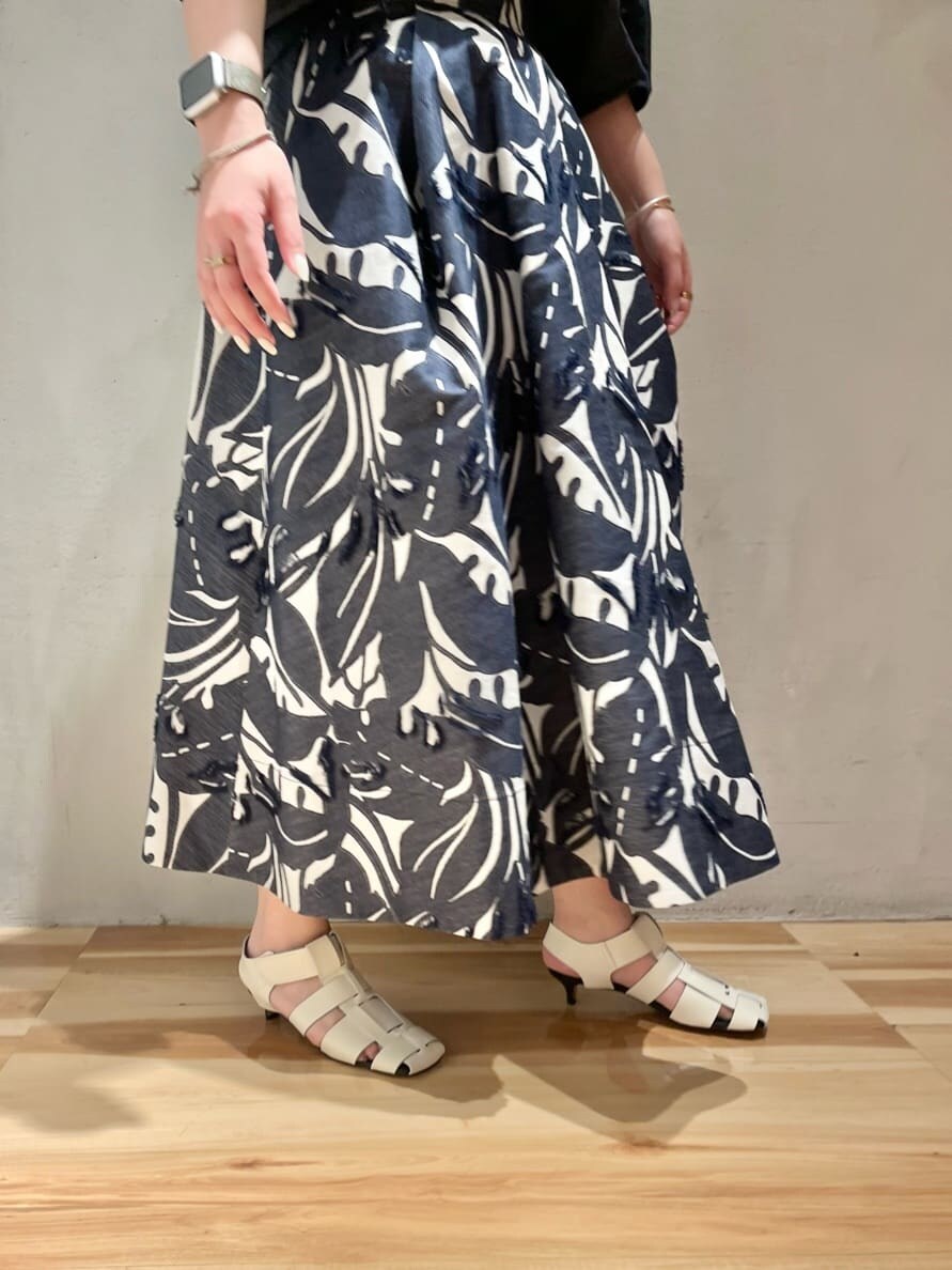 パープル系のニット/セーター、ブルー系のスカート、ブルー系のシャツ/ブラウスを着用したレディースの春コーディネートの5枚目の写真