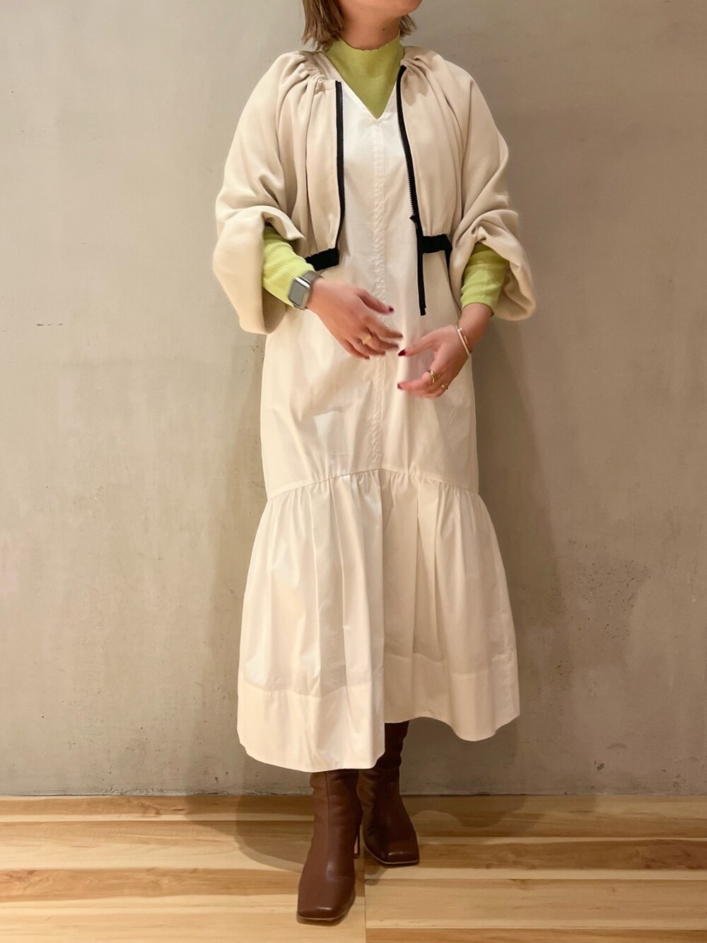 ホワイト系のワンピース、グリーン系のニット/セーターを着用したレディースの冬コーディネートの6枚目の写真