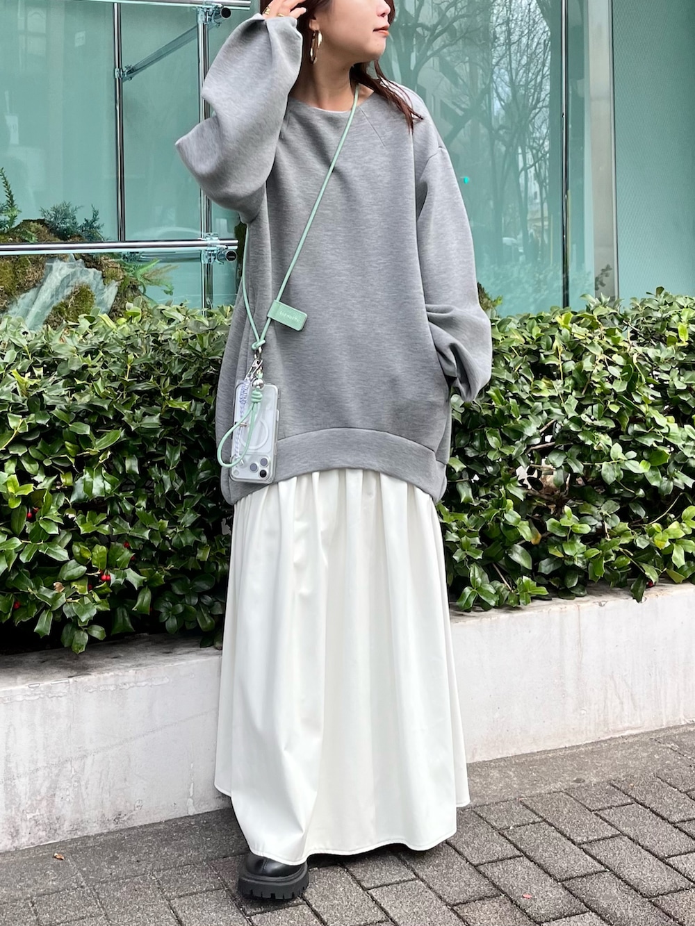 グレー系のワンピース、グリーン系のスマホケース/カバーを着用したレディースの冬コーディネートの2枚目の写真