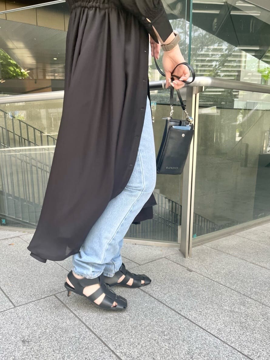 ホワイト系のキャミソール、ブラック系のワンピースを着用したレディースの春コーディネートの6枚目の写真