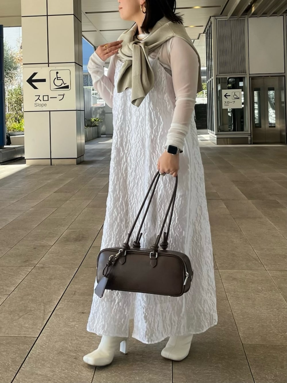 ホワイト系のTシャツ/カットソー、ホワイト系のワンピース、ホワイト系のブーツを着用したレディースの冬コーディネートの4枚目の写真