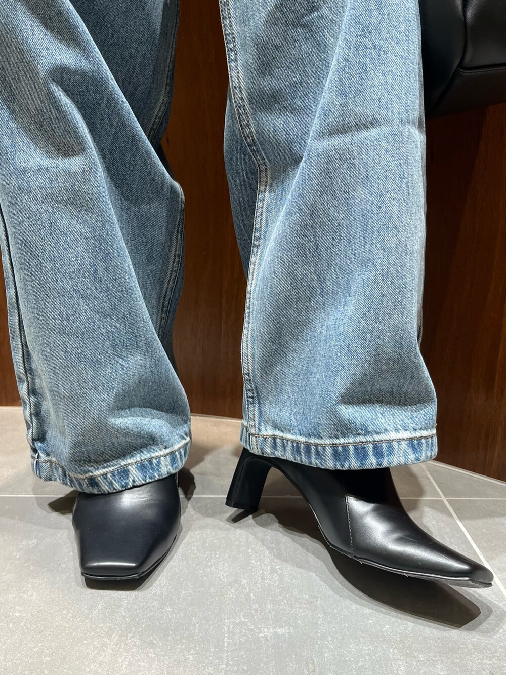 ブラック系のテーラードジャケット、レッド系のカーディガン/ボレロ、ブラック系のハンドバッグを着用したレディースの秋コーディネートの10枚目の写真