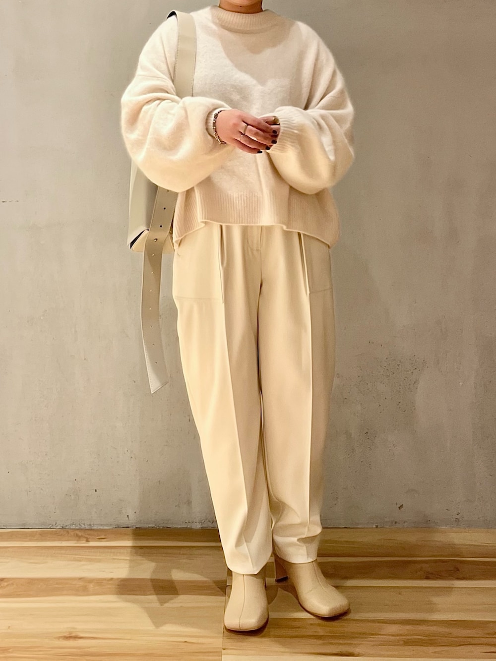 ホワイト系のニット/セーター、ホワイト系のその他パンツ、ベージュ系のブーツを着用したレディースの秋コーディネートの4枚目の写真