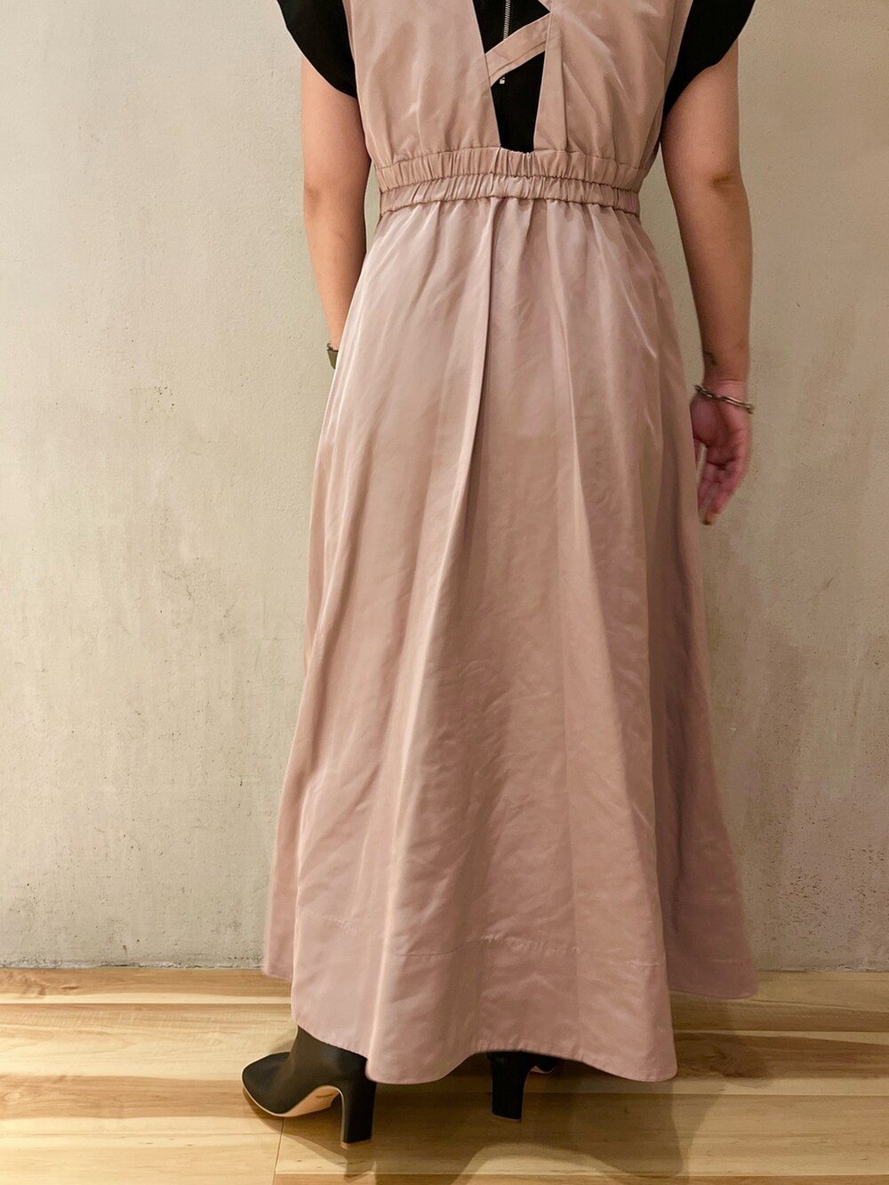 ベージュ系のジャンパースカート、ブラック系のTシャツ/カットソー、ブラック系のブーツを着用したレディースの夏コーディネートの6枚目の写真