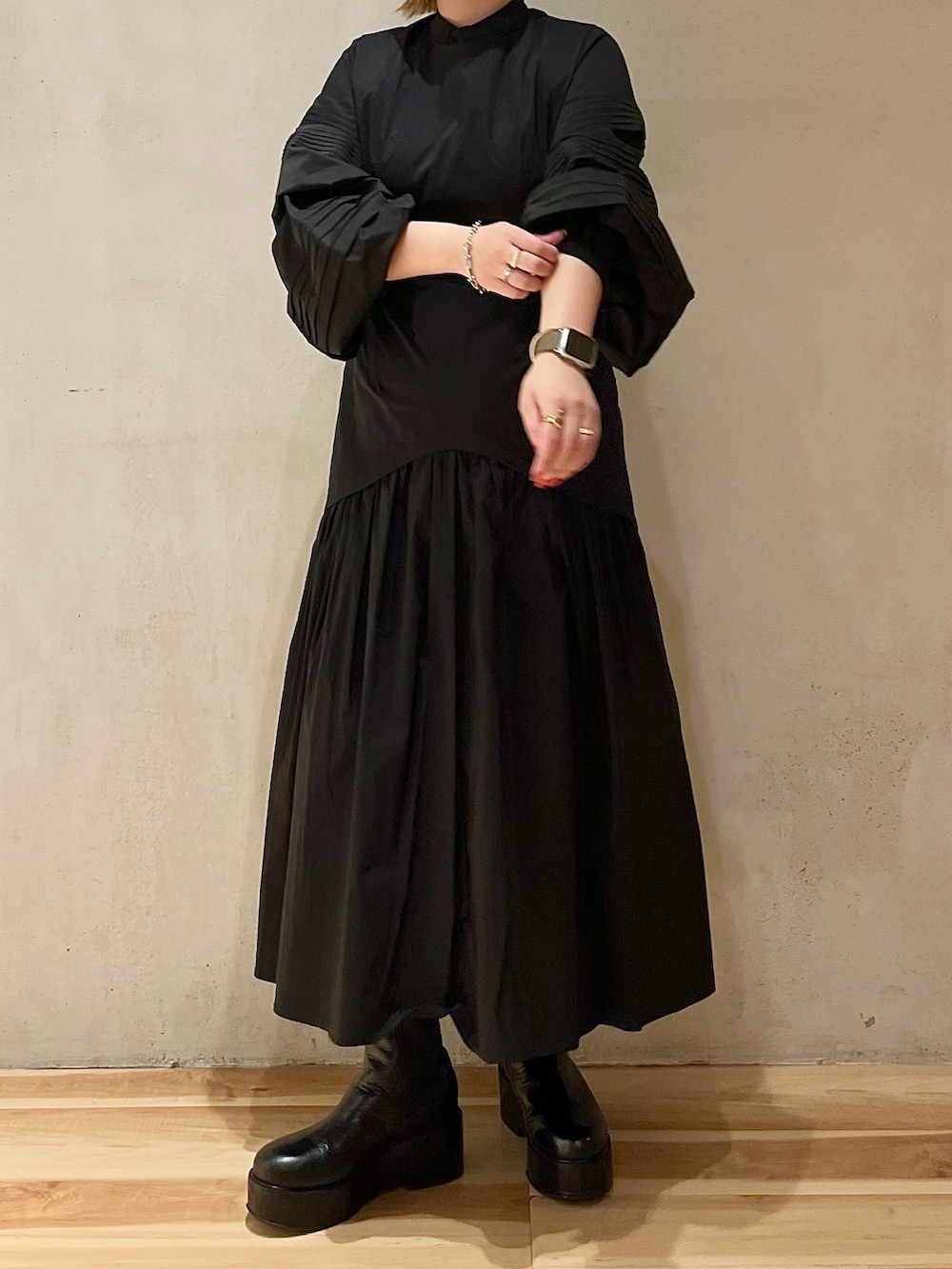 グリーン系のノーカラージャケット、ブラック系のワンピース、ブラック系のブーツを着用したレディースの秋コーディネートの6枚目の写真