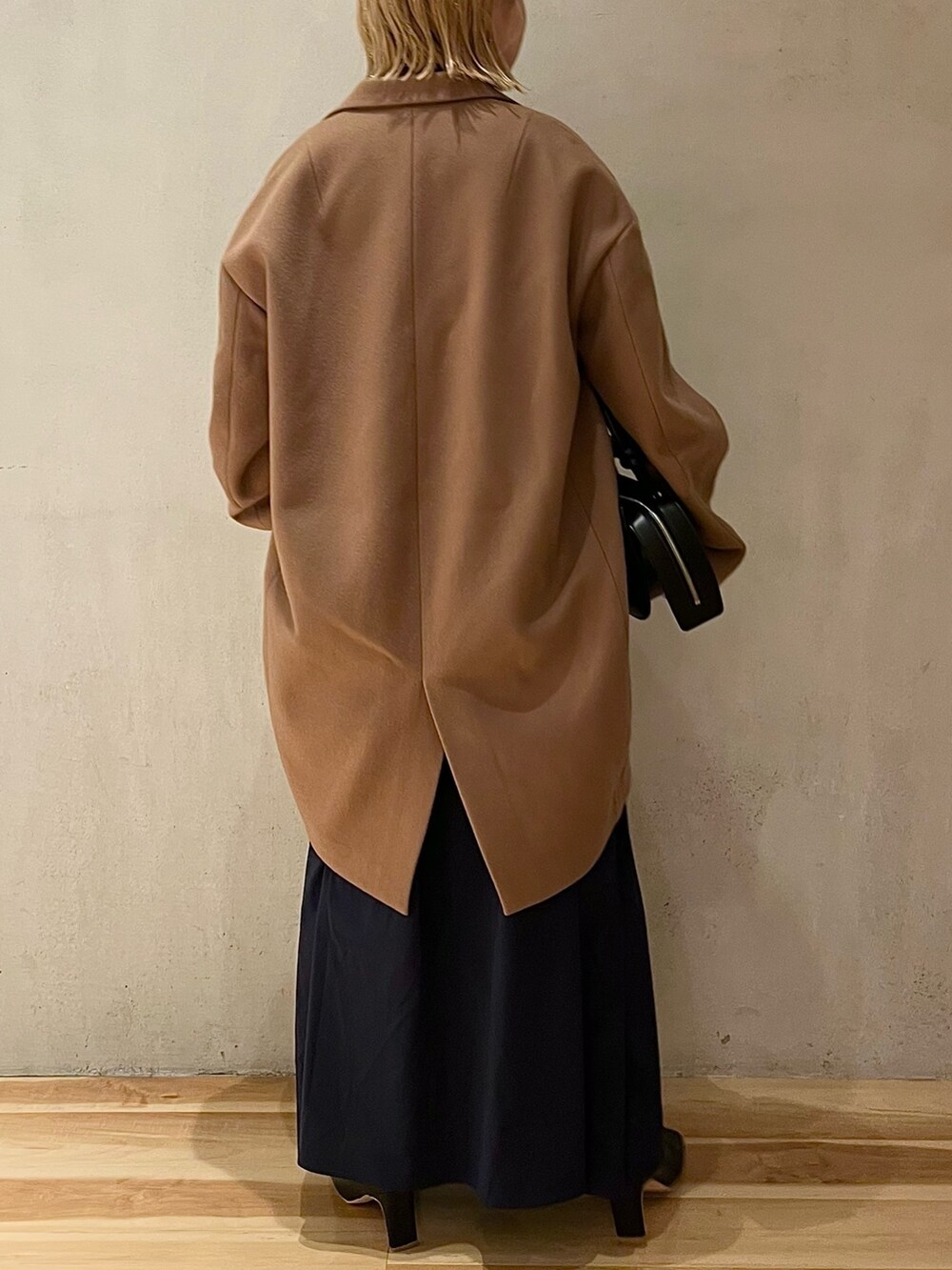 ベージュ系のチェスターコート、ブルー系のワンピース、ブラック系のブーツを着用したレディースの夏コーディネートの4枚目の写真