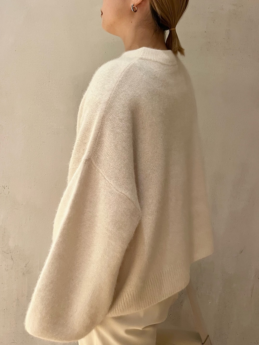 ホワイト系のニット/セーター、ホワイト系のその他パンツ、ベージュ系のブーツを着用したレディースの秋コーディネートの6枚目の写真