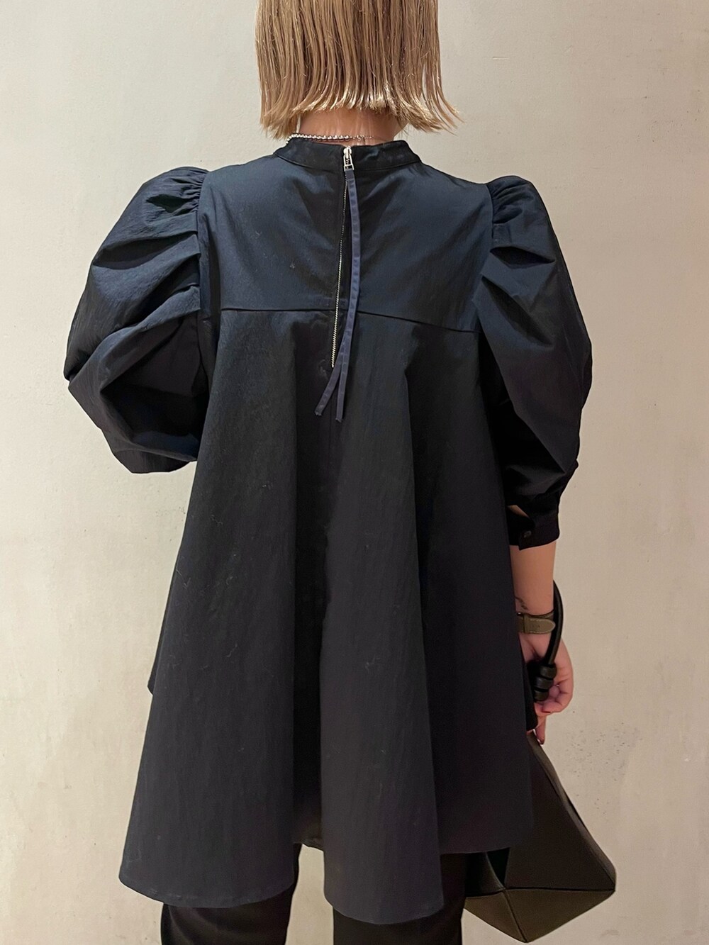 ブラック系のハンドバッグ、ブラック系のその他パンツ、ブラック系のシャツ/ブラウスを着用したレディースの冬コーディネートの5枚目の写真