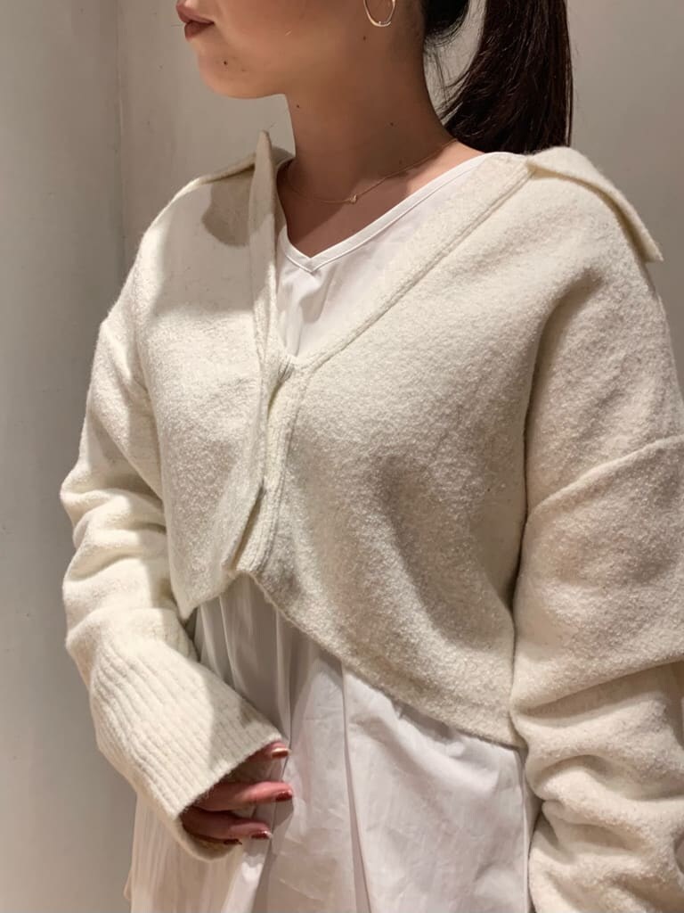 ブラウン系のスラックス、ブラック系のブーツ、ホワイト系のニット/セーターを着用したレディースの秋コーディネートの4枚目の写真