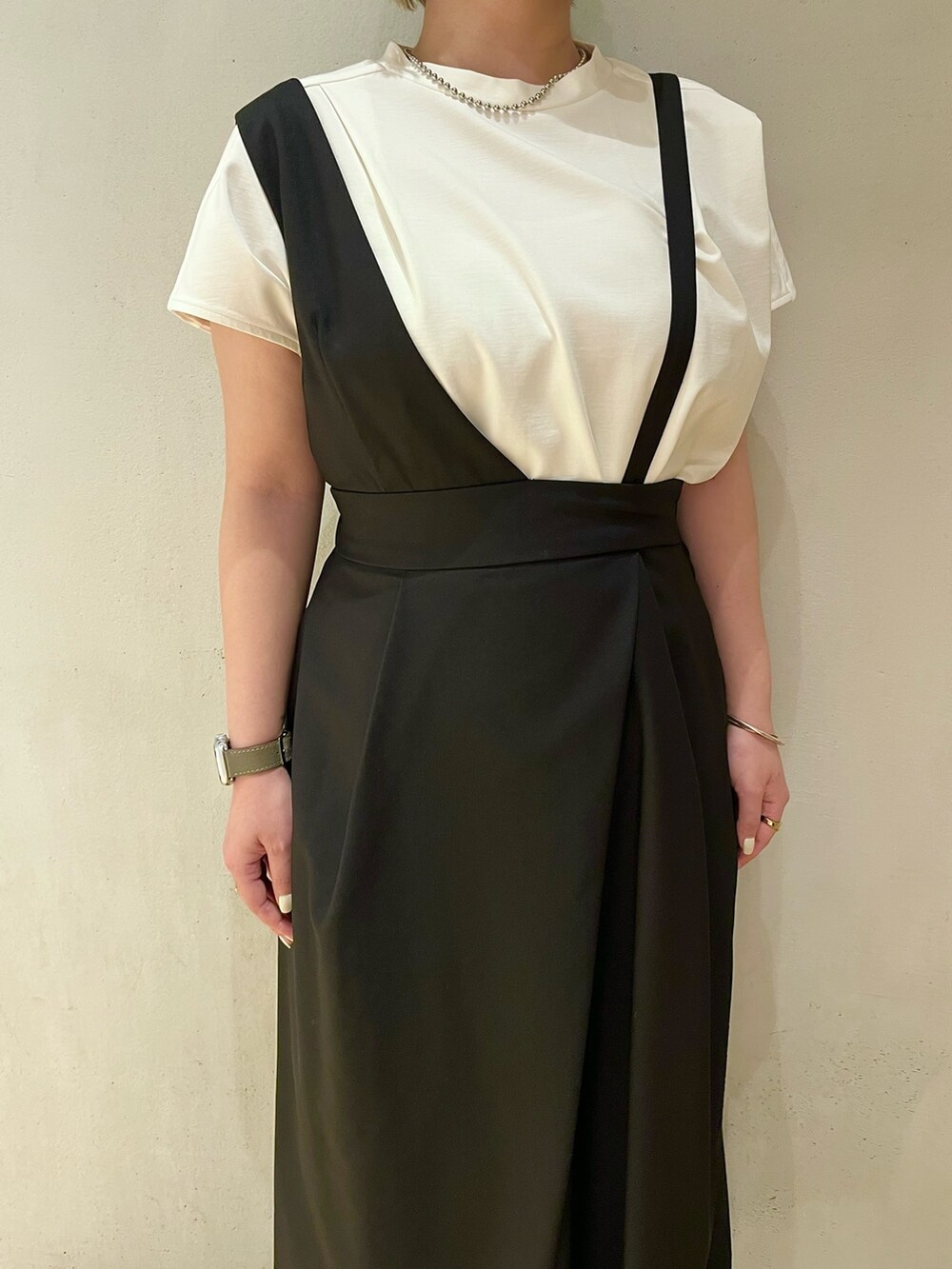 ホワイト系のTシャツ/カットソー、ブラック系のジャンパースカート、シルバー系のネックレスを着用したレディースの春コーディネートの5枚目の写真