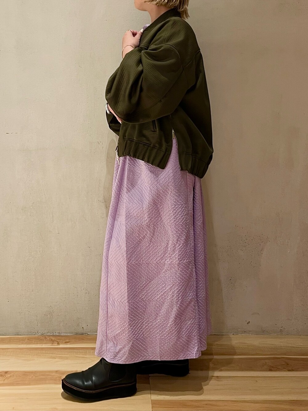 グリーン系のブルゾン、パープル系のワンピースを着用したレディースの春コーディネートの2枚目の写真