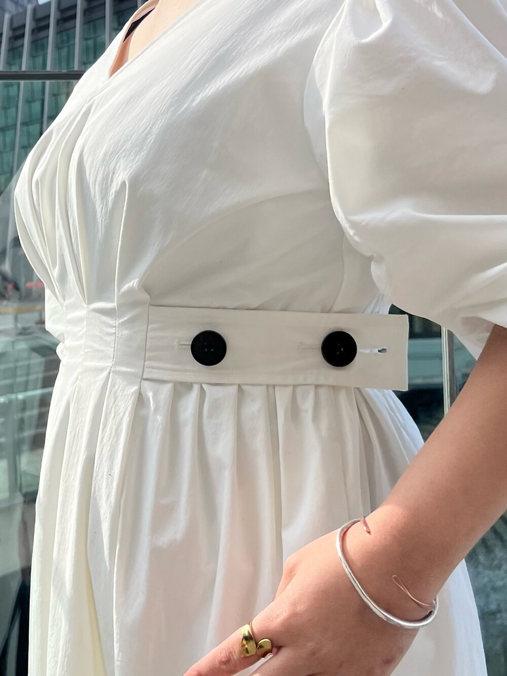 ブラック系のサンダル、ホワイト系のワンピース、ブラック系のハンドバッグを着用したレディースの冬コーディネートの7枚目の写真