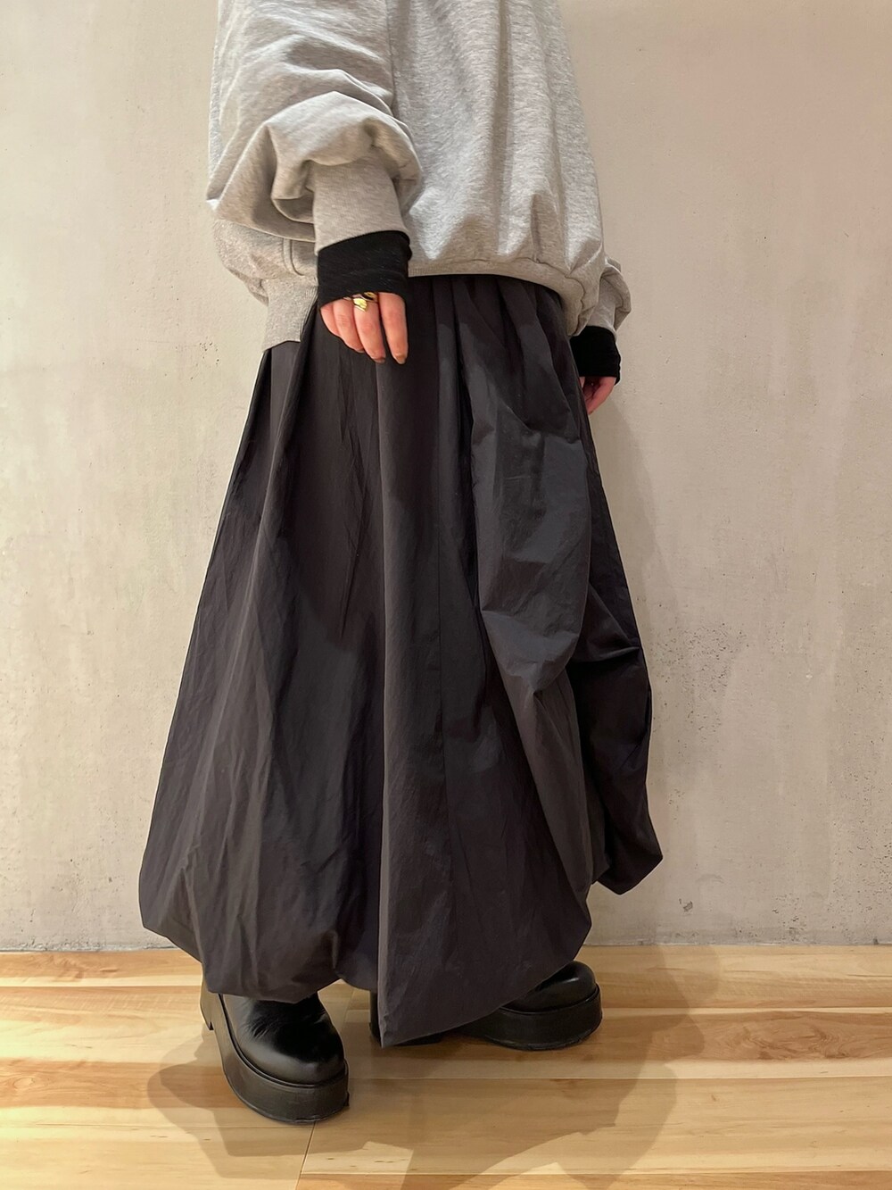 グレー系のスウェット、ブラック系のTシャツ/カットソー、ブラック系のスカートを着用したレディースの冬コーディネートの8枚目の写真