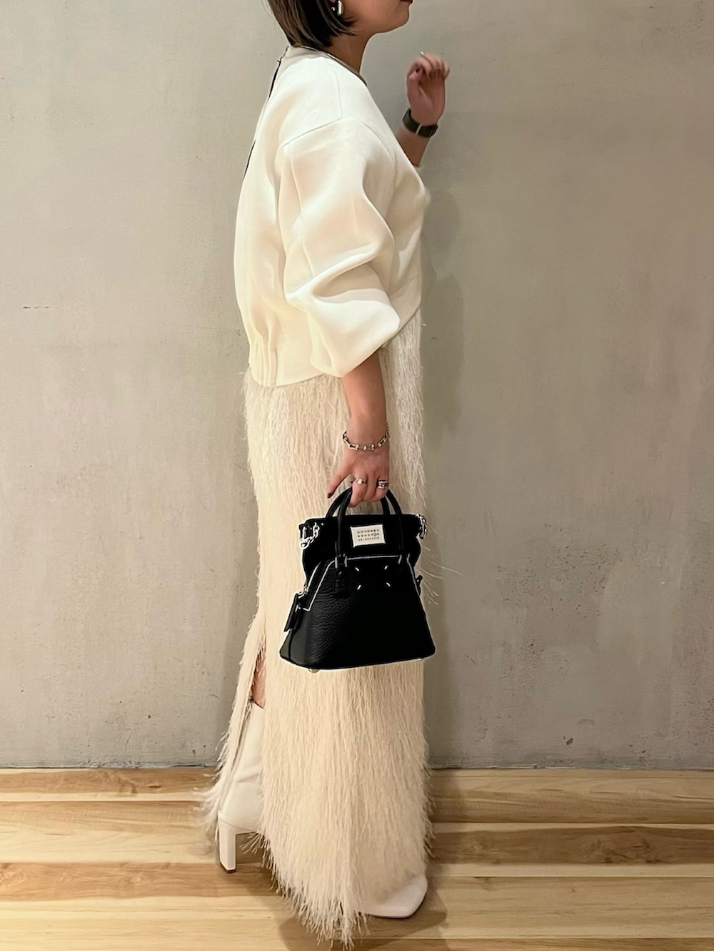 ホワイト系のTシャツ/カットソー、ホワイト系のスカート、ホワイト系のブーツを着用したレディースの春コーディネートの3枚目の写真