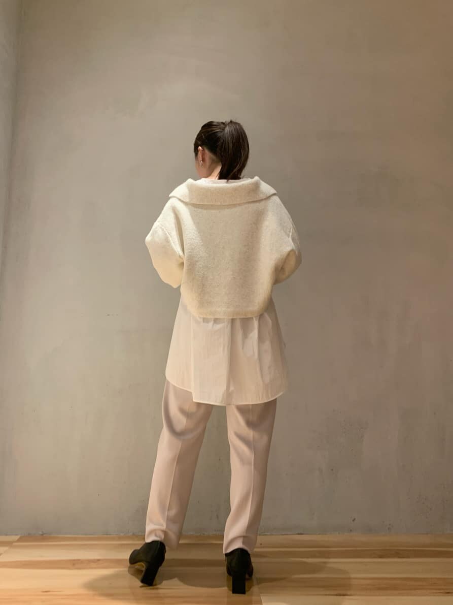 ブラウン系のスラックス、ブラック系のブーツ、ホワイト系のニット/セーターを着用したレディースの秋コーディネートの3枚目の写真