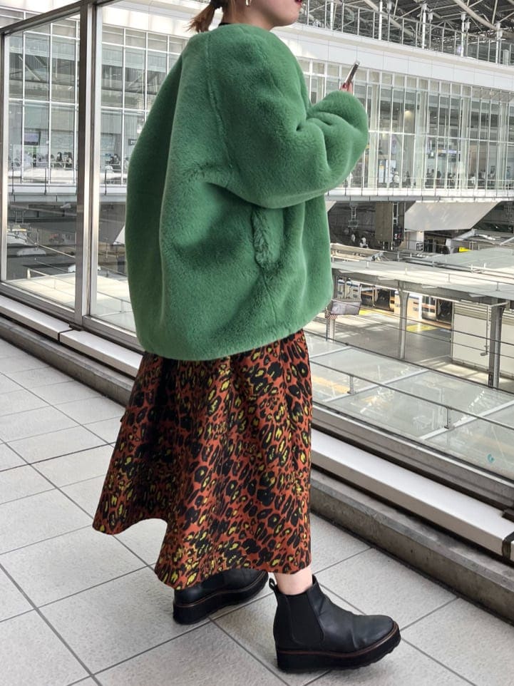 ブラック系のニット/セーター、ホワイト系のショルダーバッグ、グリーン系のノーカラーコートを着用したレディースの夏コーディネートの2枚目の写真