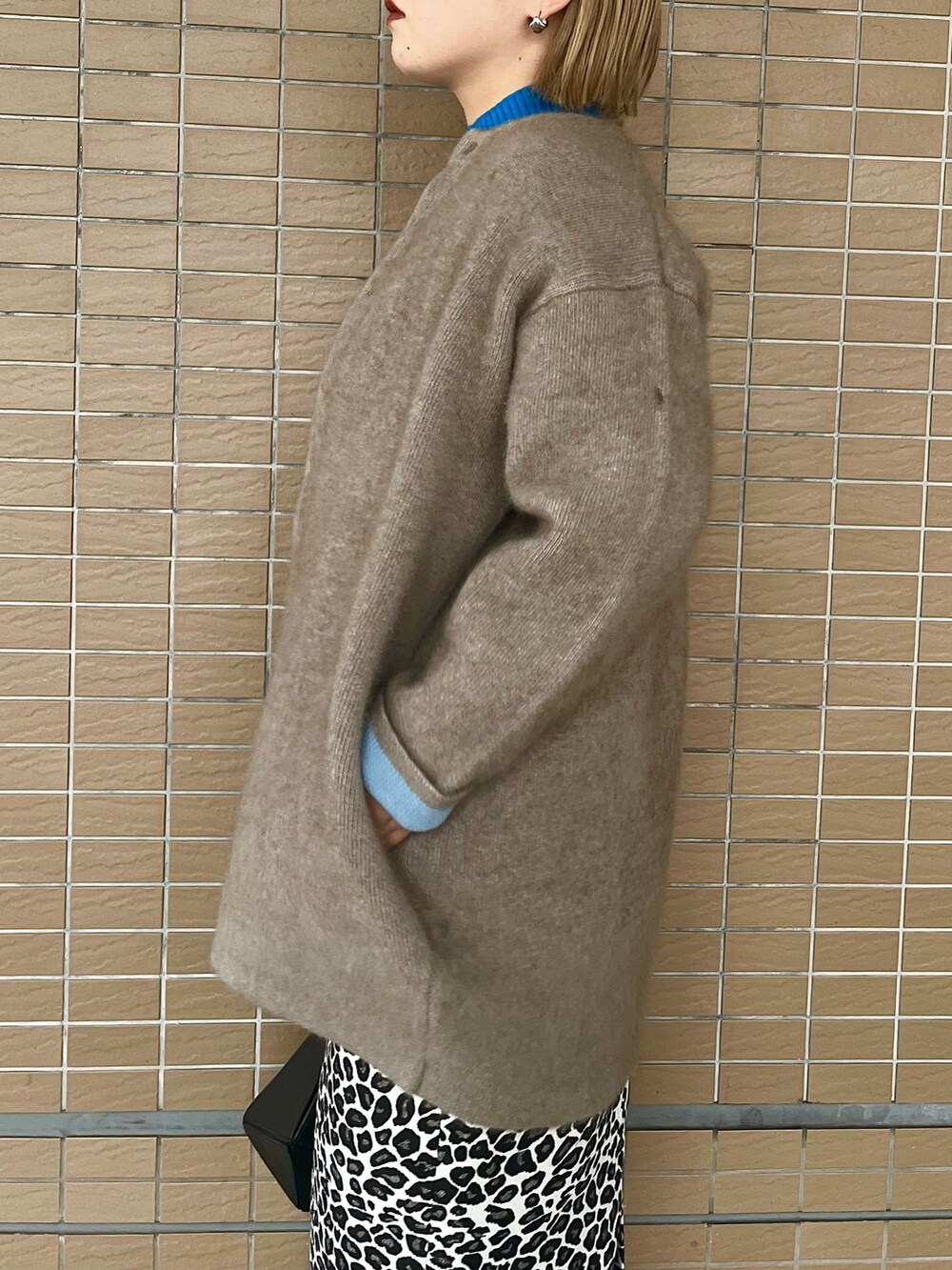 ベージュ系のノーカラージャケット、ブラック系のブーツ、ブラック系のハンドバッグを着用したレディースの夏コーディネートの6枚目の写真