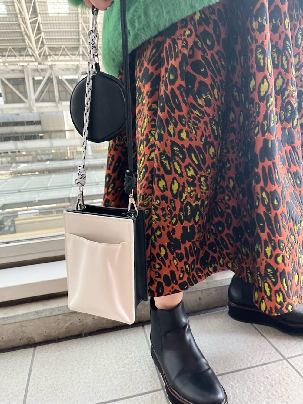 ブラック系のニット/セーター、ホワイト系のショルダーバッグ、グリーン系のノーカラーコートを着用したレディースの夏コーディネートの8枚目の写真