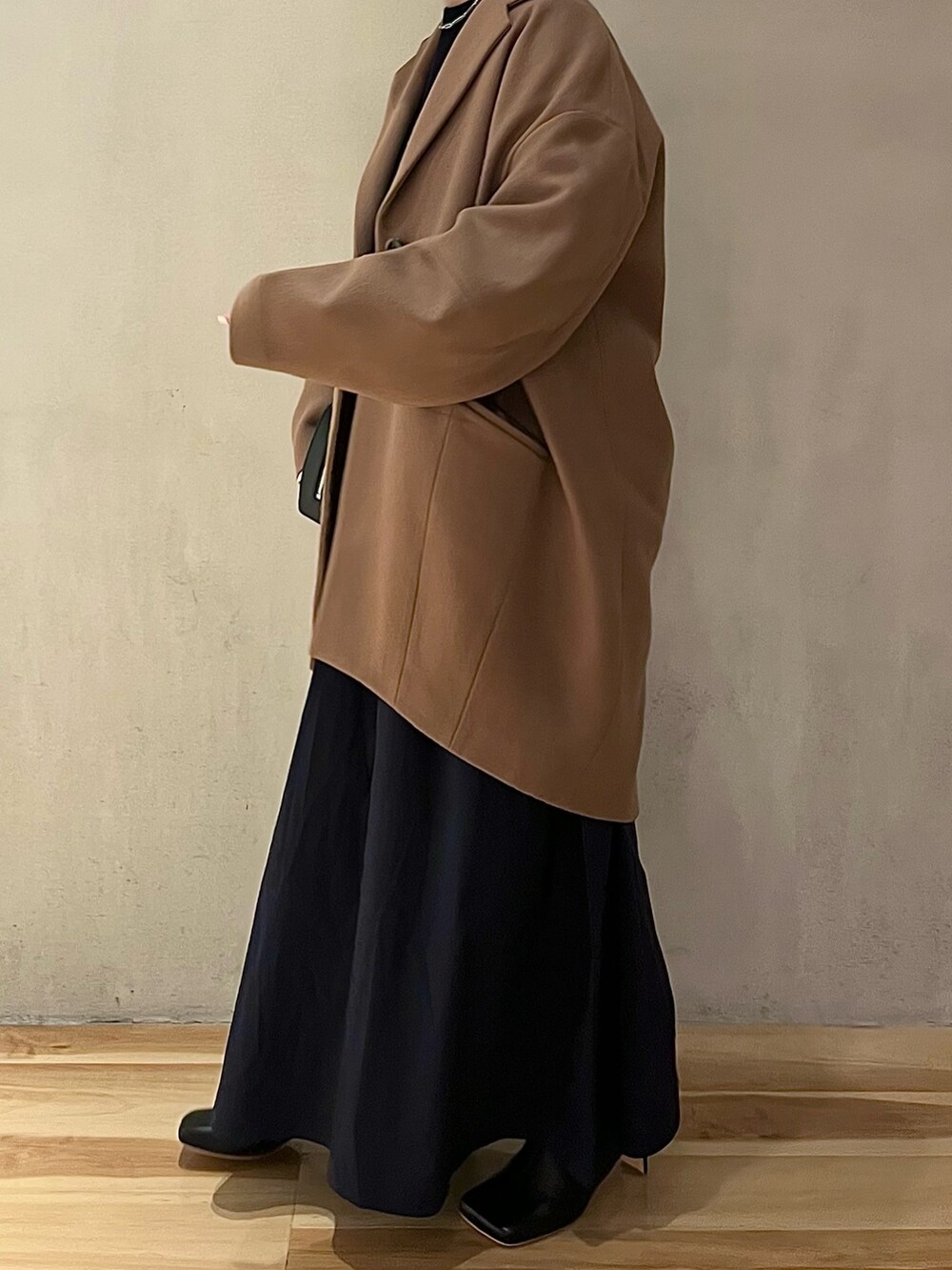 ベージュ系のチェスターコート、ブルー系のワンピース、ブラック系のブーツを着用したレディースの夏コーディネートの3枚目の写真