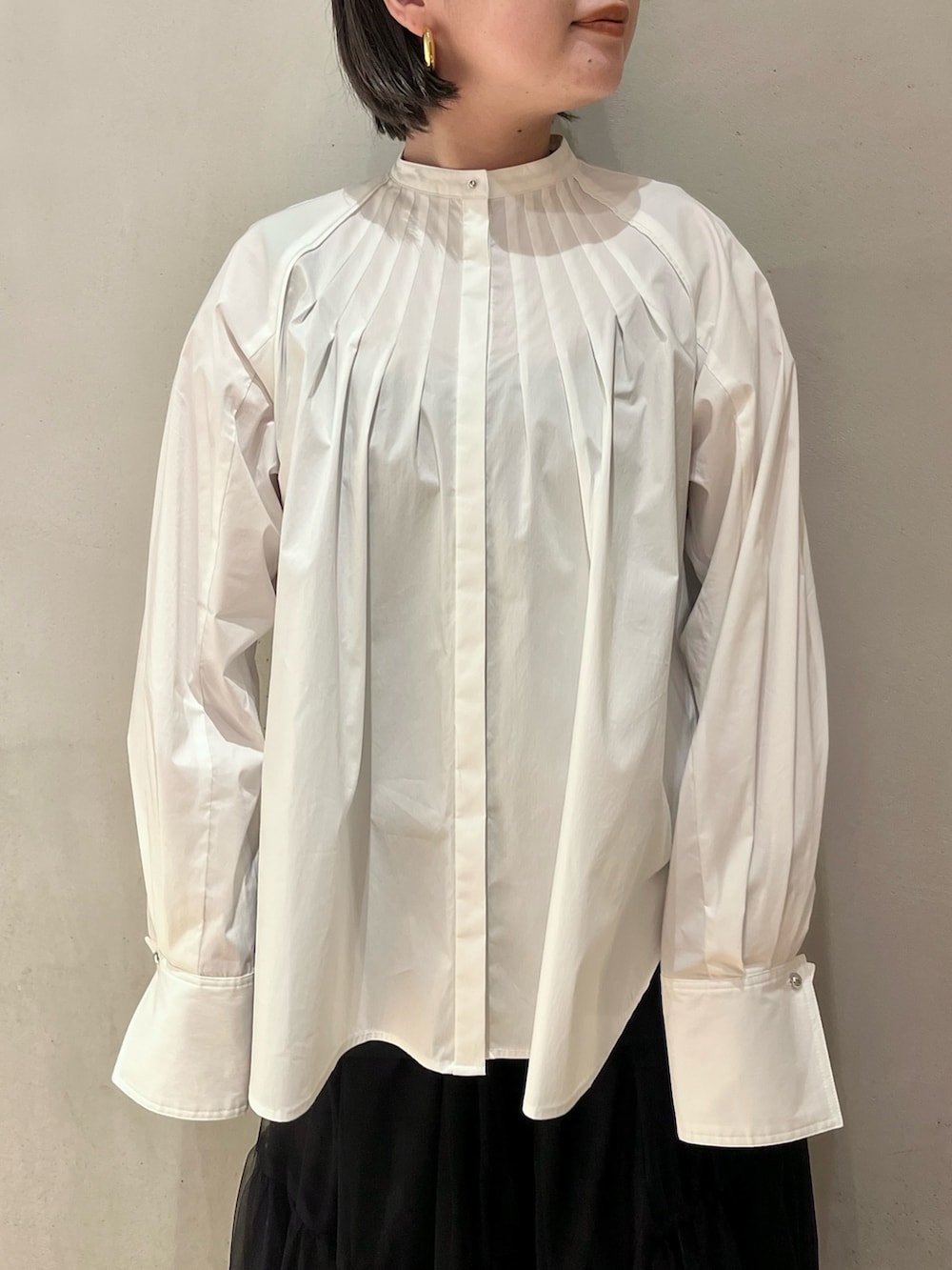 ブラック系のスカート、シルバー系のパンプス、ホワイト系のシャツ/ブラウスを着用したレディースの冬コーディネートの4枚目の写真