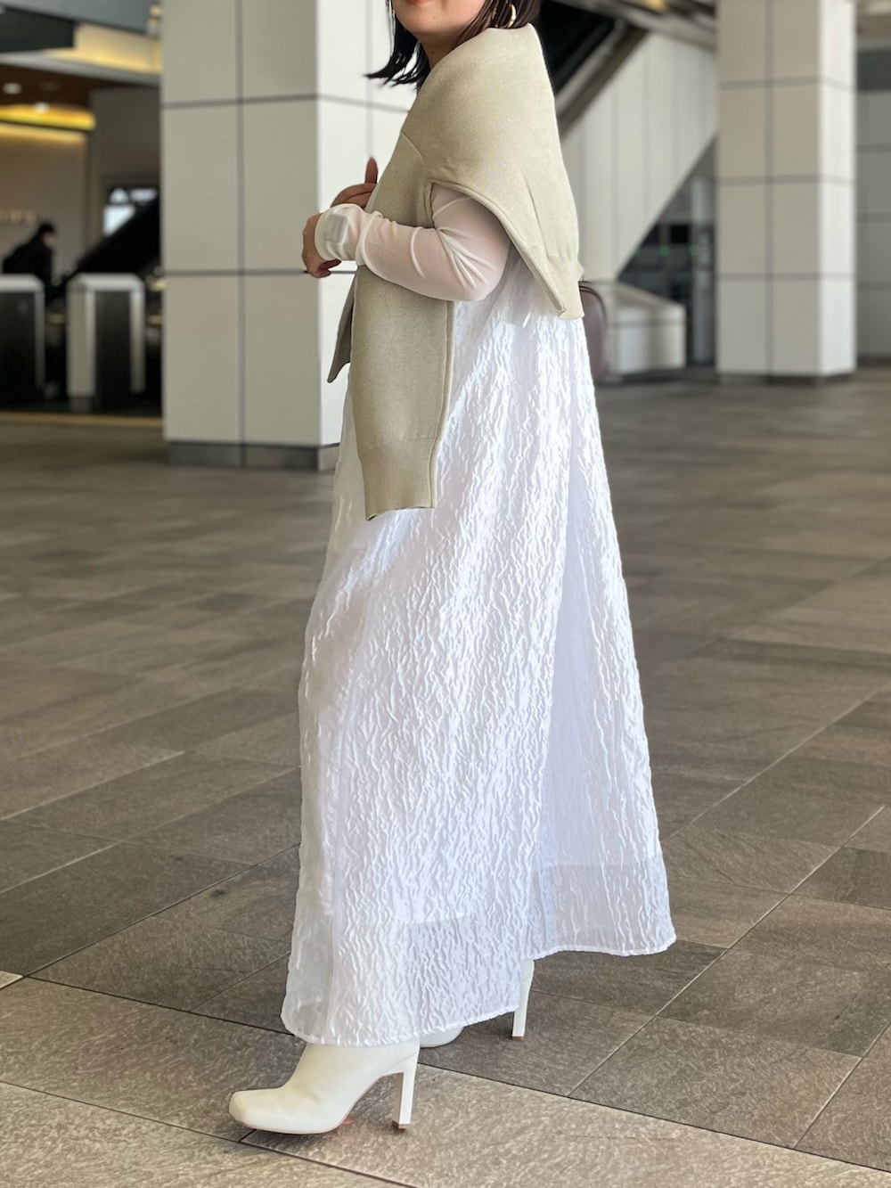 ホワイト系のTシャツ/カットソー、ホワイト系のワンピース、ホワイト系のブーツを着用したレディースの冬コーディネートの6枚目の写真