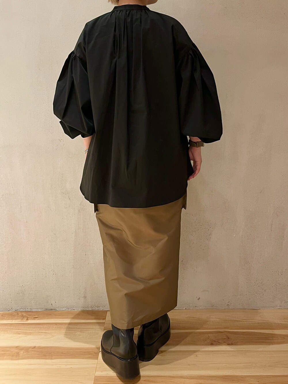 ブラック系のシャツ/ブラウス、ブラウン系のスカート、ブラック系のブーツを着用したレディースの春コーディネートの3枚目の写真