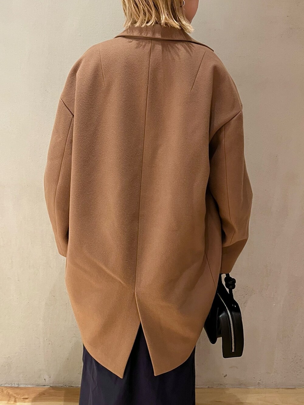 ベージュ系のチェスターコート、ブルー系のワンピース、ブラック系のブーツを着用したレディースの夏コーディネートの7枚目の写真