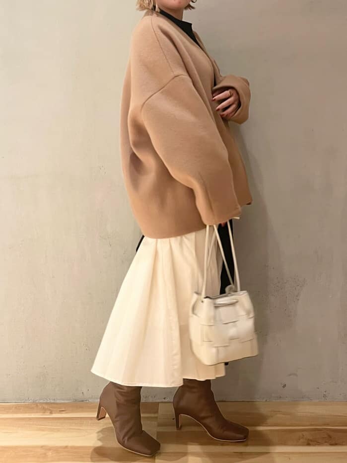 ブラウン系のブーツ、ブラック系のワンピース、イエロー系のノーカラーコートを着用したレディースの秋コーディネートの2枚目の写真