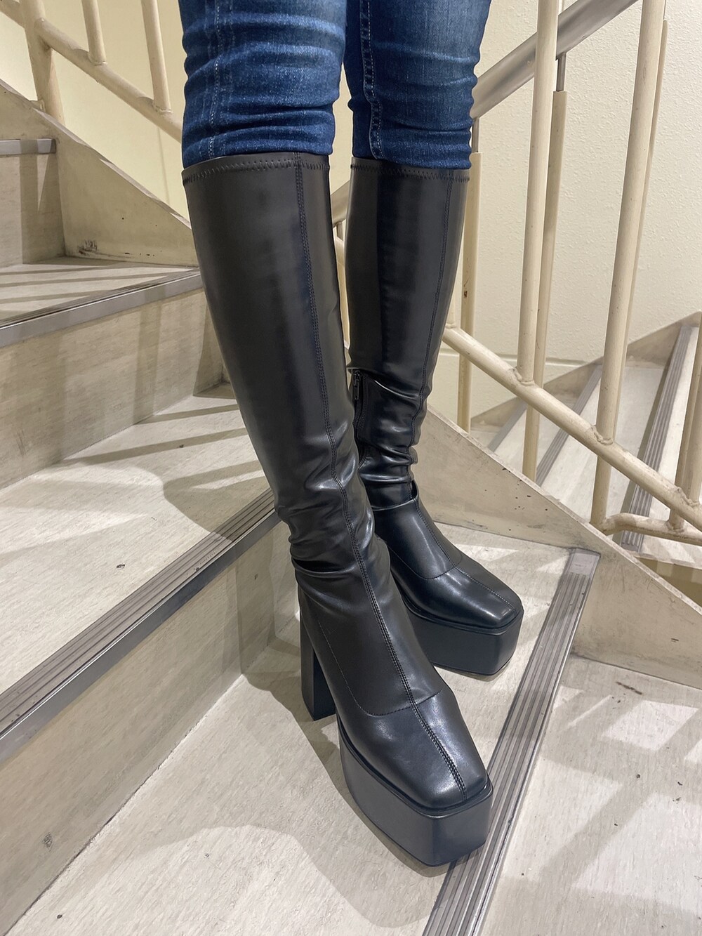 ブルー系のデニムパンツ、ホワイト系のニット/セーター、グレー系のライダースジャケットを着用したレディースの秋コーディネートの8枚目の写真