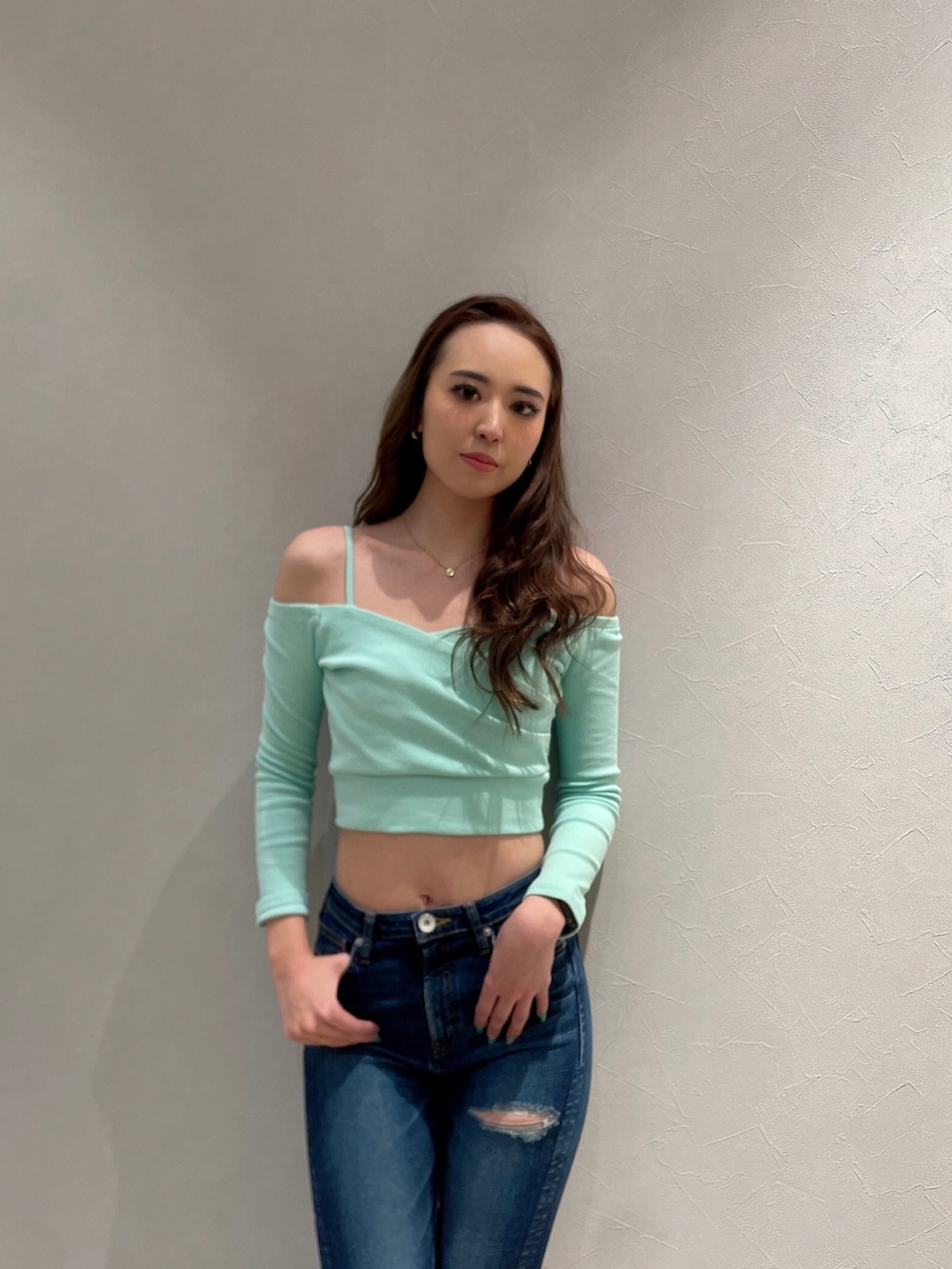 グリーン系のTシャツ/カットソー、ブルー系のデニムパンツ、ブラック系のパンプスを着用したレディースの春コーディネートの3枚目の写真