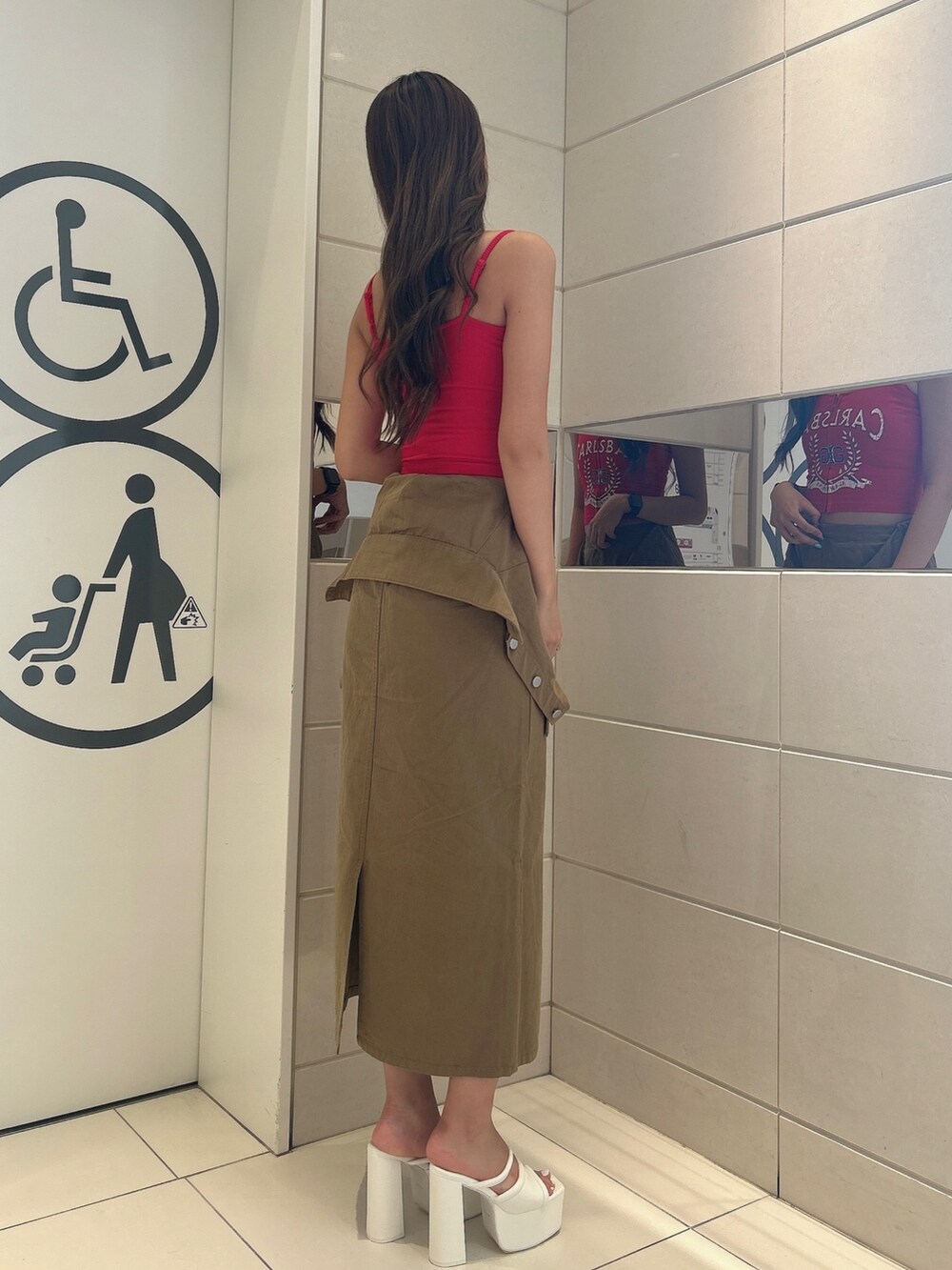 レッド系のキャミソール、グリーン系のスカート、ホワイト系のサンダルを着用したレディースの夏コーディネートの2枚目の写真