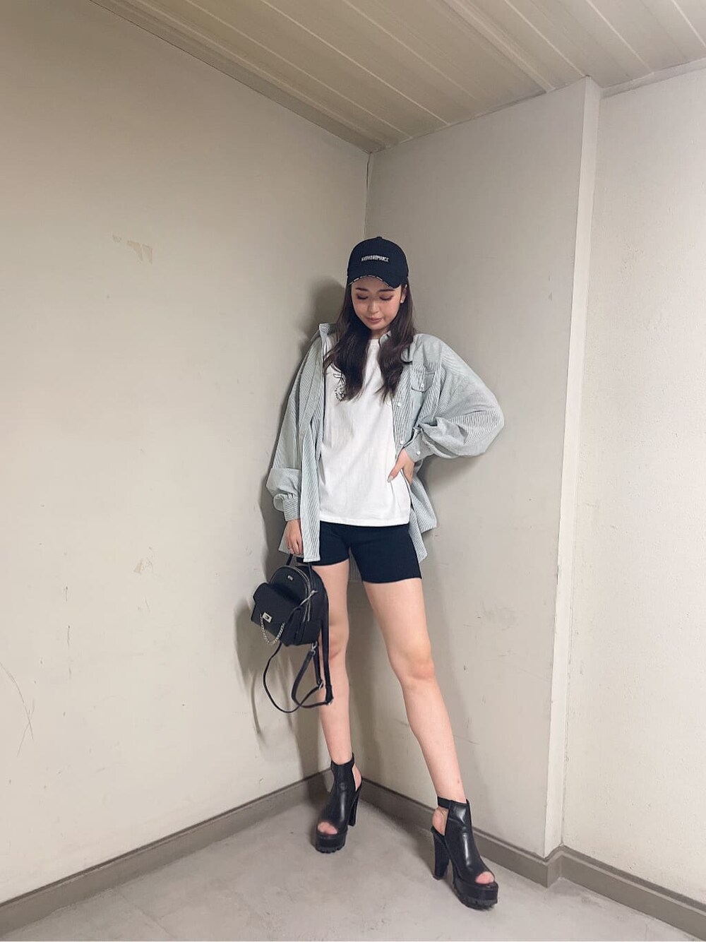 グリーン系のシャツ/ブラウス、ブラック系のバックパック/リュック、ブラック系のブーツを着用したレディースの春コーディネートの3枚目の写真