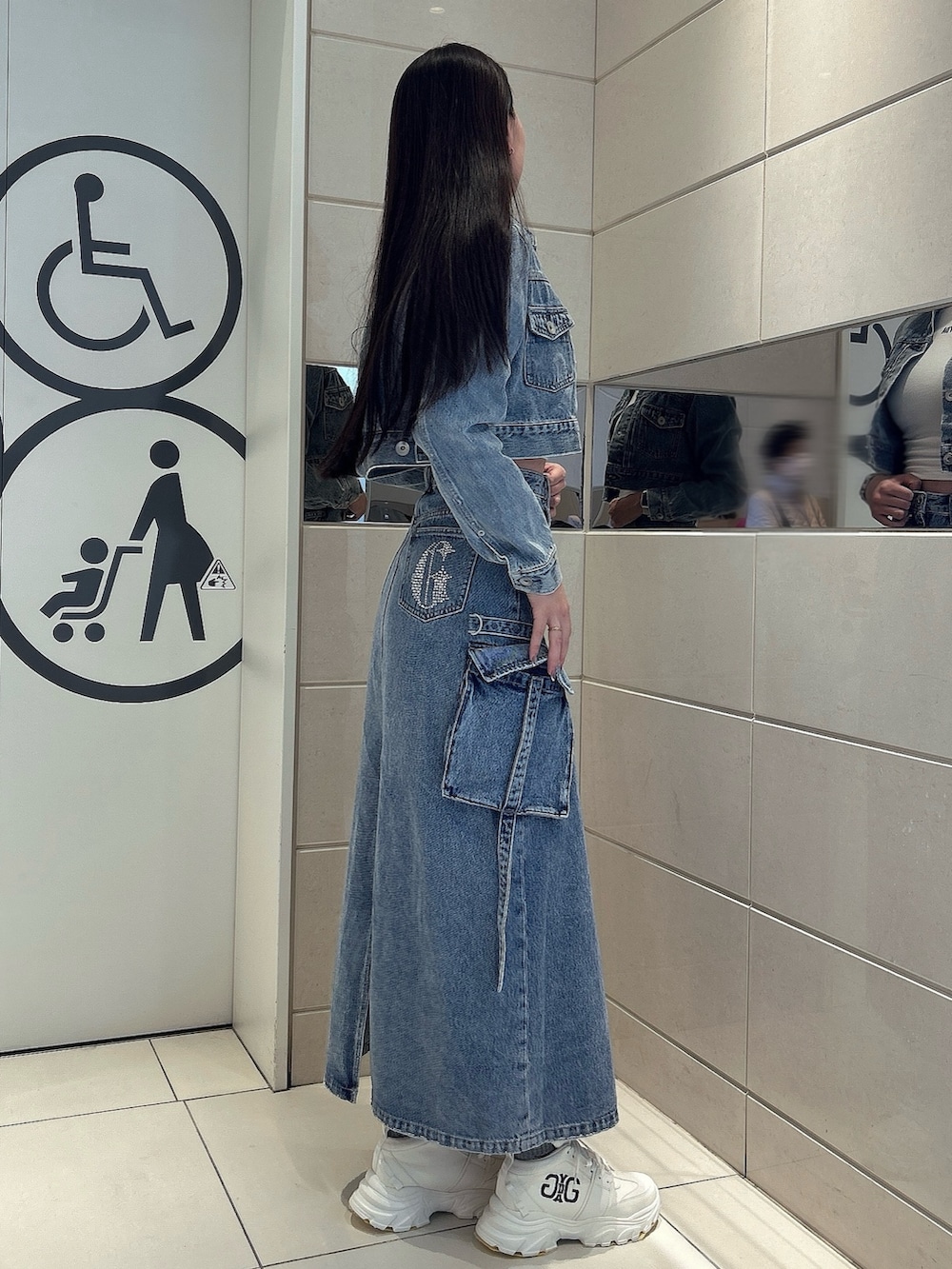 ホワイト系のスニーカー、ブルー系のデニムスカート、ブルー系のデニムジャケットを着用したレディースの冬コーディネートの2枚目の写真