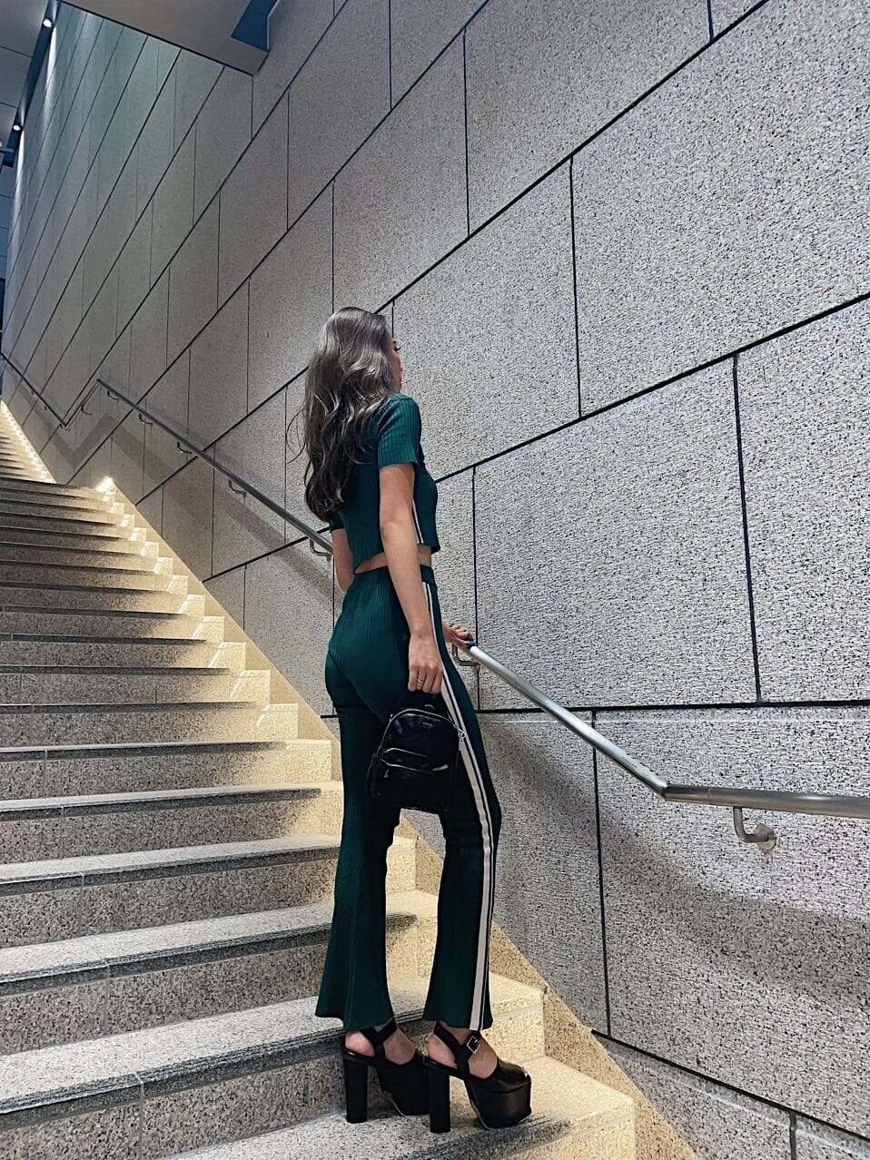 グリーン系のその他パンツ、グリーン系のニット/セーター、ブラック系のバックパック/リュックを着用したレディースの夏コーディネートの2枚目の写真