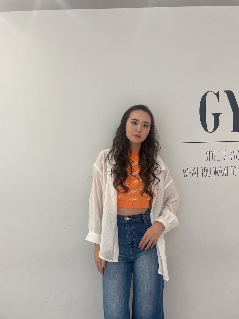 ブルー系のデニムパンツ、ホワイト系のシャツ/ブラウス、ベージュ系のサンダルを着用したレディースの春コーディネートの3枚目の写真