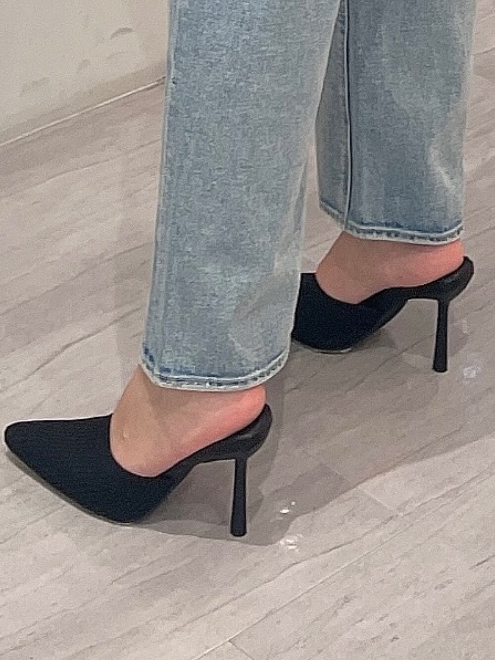 ブラック系のパンプス、その他のニット/セーター、ブルー系のデニムパンツを着用したレディースの冬コーディネートの7枚目の写真