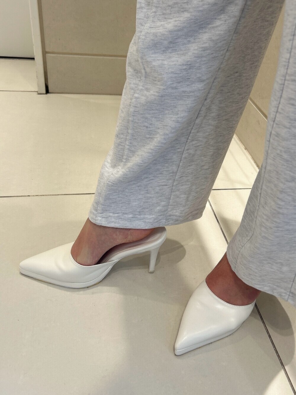 ホワイト系のパンプス、グレー系のスウェット、グレー系のスウェットパンツを着用したレディースの冬コーディネートの9枚目の写真