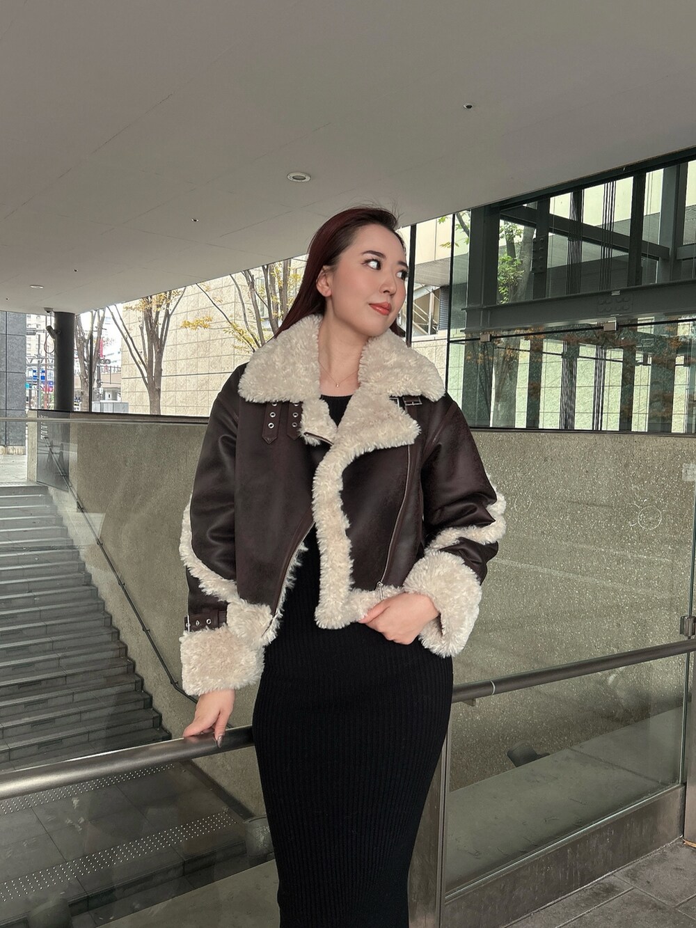 ブラウン系のムートンコート、ブラック系のブーツを着用したレディースの秋コーディネートの4枚目の写真